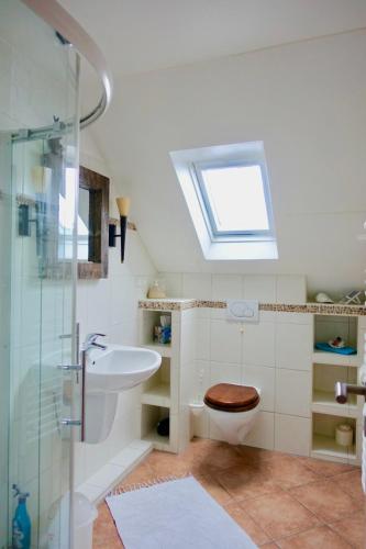 a bathroom with a sink and a toilet and a skylight at Haus am Wald Klingberg in Klingberg