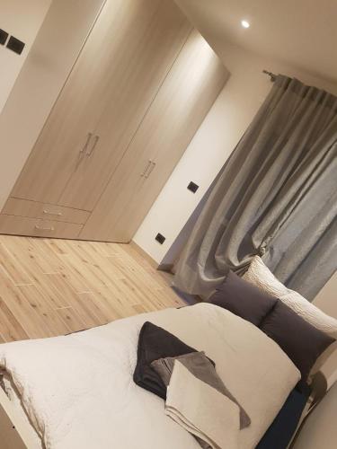 a bedroom with a bed with a window and a curtain at Alloggio Casa Talvena XL in Longarone