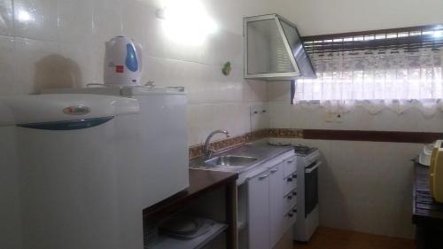 a small white kitchen with a sink and a stove at ITALIA RANCH in Punta del Este