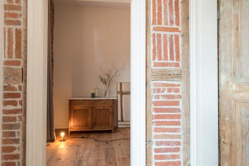 an empty room with a table and a brick wall at Palais Wunderlich in Lahr