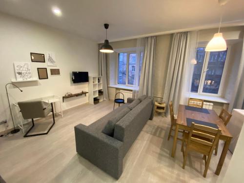 莫斯科的住宿－Aparthotel Lind，客厅配有灰色的沙发和桌子
