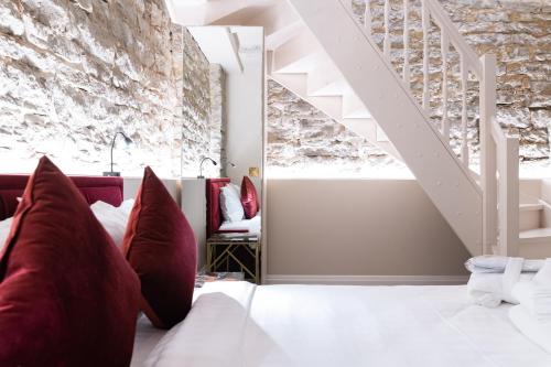 a bedroom with a white bed with red pillows at Hotel Meltzer Apartments in Tallinn