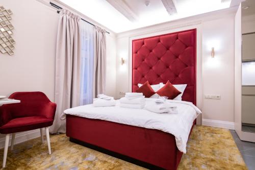 a bedroom with a red headboard and a red chair at Hotel Meltzer Apartments in Tallinn
