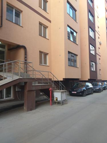 a parking lot with cars parked in front of a building at Luxury Daniel Apartament Residence Militari in Roşu