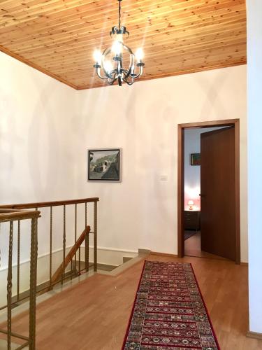 a room with a staircase and a ceiling with a chandelier at Grandpa’s Home in Gjirokastër