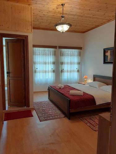 1 dormitorio con 1 cama grande con manta roja en Grandpa’s Home, en Gjirokastra