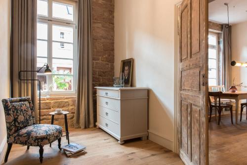a room with a dresser and a chair and a window at Palais Wunderlich in Lahr