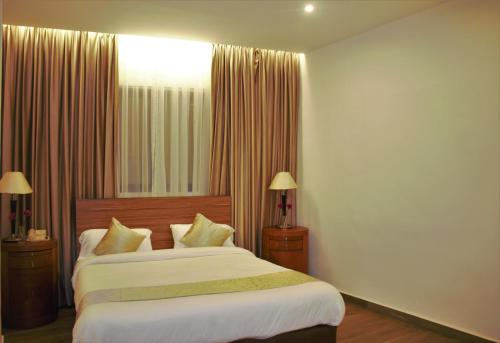 a bedroom with a large bed with white sheets at New MerryLand Hotel in Amman