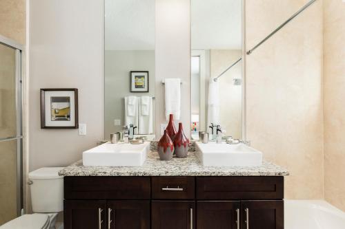 a bathroom with two sinks and a large mirror at 5min Disney Fantastic Townhome, BBQ 116 in Orlando