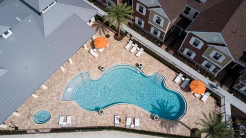 an overhead view of a swimming pool with chairs and umbrellas at 5min Disney Fantastic Townhome, BBQ 116 in Orlando