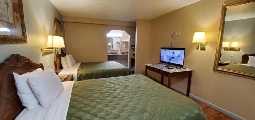 a hotel room with two beds and a flat screen tv at FairBridge Inn & Suites in McDonough