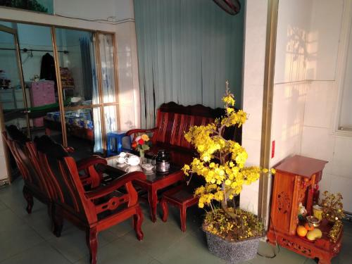 una sala da pranzo con tavolo, sedie e fiori di Hai Hien Guesthouse a Phu Quoc