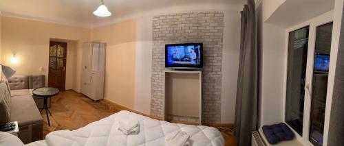 ein Wohnzimmer mit einem Sofa und einem TV an der Wand in der Unterkunft Mary in Lwiw