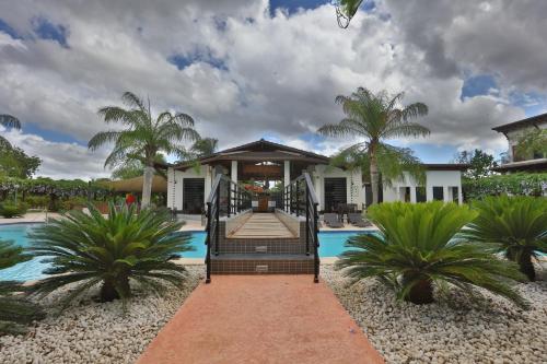 une villa avec une piscine et une maison dans l'établissement Sybaris Suites & Residences, à Juan Dolio