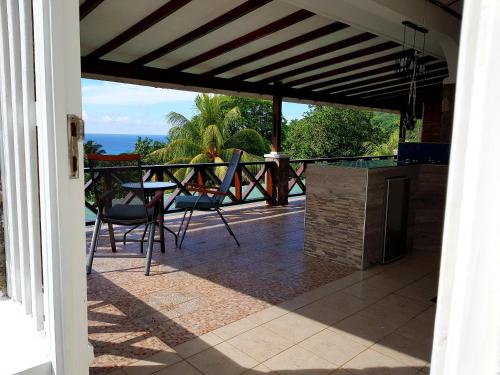 a patio with a view of the ocean from a house at Rose Self Catering in Beau Vallon