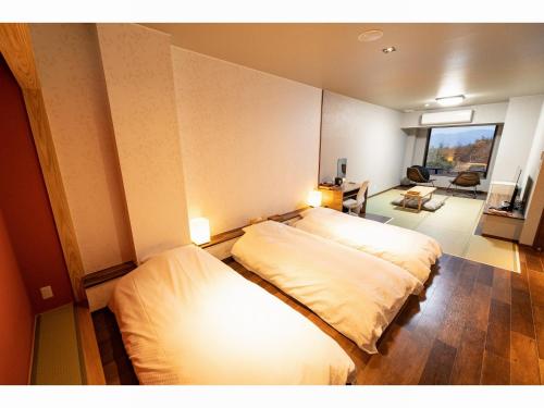 um quarto com 2 camas e uma sala de estar em Kajitsu no Mori em Ichinoseki