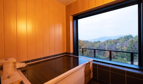 um quarto vazio com uma grande janela com vista em Kajitsu no Mori em Ichinoseki