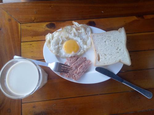 a plate with an egg and a piece of bread and toast at Bebe Homestay Phu Quoc in Phu Quoc