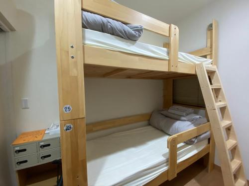 a bunk bed in a room with a desk at Upper Hotel Ryogoku in Tokyo