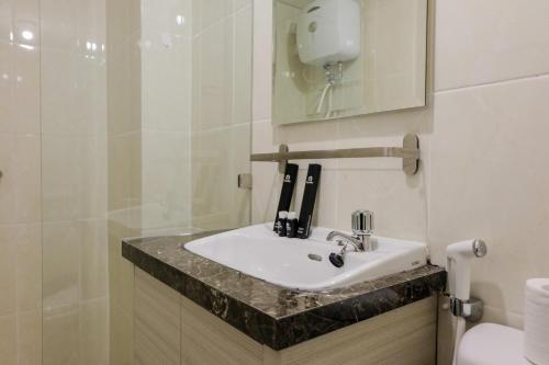 タンゲランにあるFully Parquette City View Studio Apartment at M-Town Residence By Travelioの洗面台とトイレ付きのバスルーム