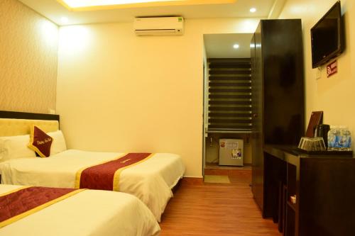 a hotel room with two beds and a television at Phuong Nam Hotel in Sa Pa