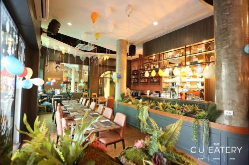 a restaurant with tables and chairs and a bar at C U Inn Bangkok in Bangkok