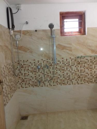 Un baño con ducha con puerta de cristal. en Yala Redhill, en Yala