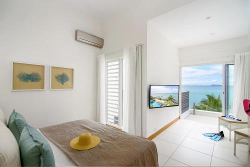 a room with a bed and a view of the ocean at Myra Seafront Suites with LOV in Cap Malheureux