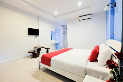 a white bedroom with a bed and a television at March Samui Resort in Mae Nam