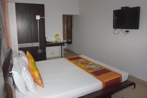 a bedroom with a bed with a tv on the wall at The Leef Inn 500ms from Nakki Lake in Mount Ābu