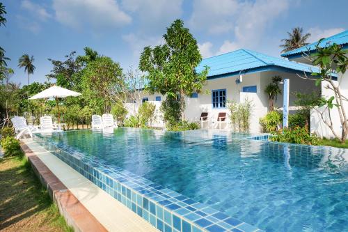 a swimming pool in front of a villa at March Samui Resort in Mae Nam