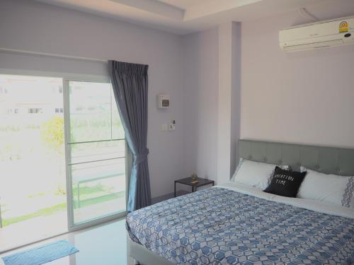 1 dormitorio con cama y ventana grande en Maharak Resort, en Nong Khai