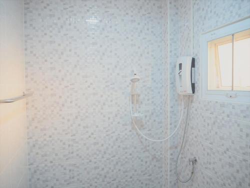 a shower in a bathroom with a phone on the wall at Maharak Resort in Nong Khai