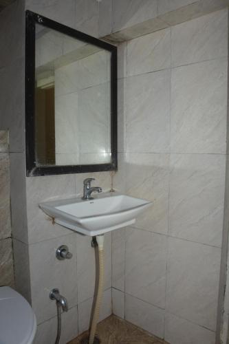 a bathroom with a sink and a mirror at The Leef Inn 500ms from Nakki Lake in Mount Ābu