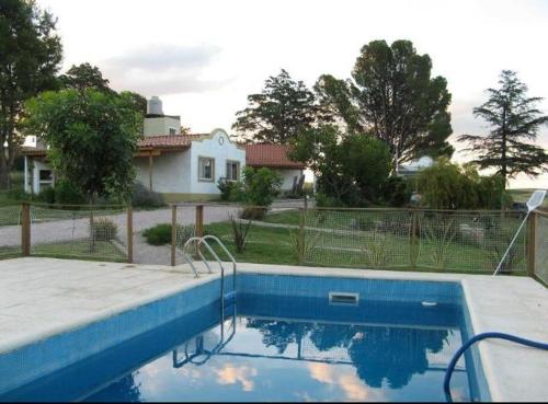 una piscina azul frente a una casa en La Candelaria - Casas de Campo - en Sierra de la Ventana