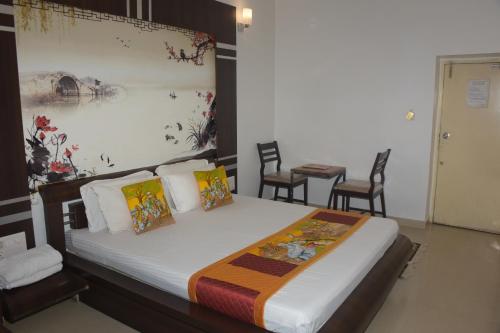 a bedroom with a bed with a painting on the wall at The Leef Inn 500ms from Nakki Lake in Mount Ābu