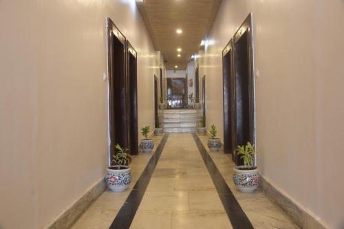 a hallway with potted plants and stairs in a building at The Leef Inn 500ms from Nakki Lake in Mount Ābu