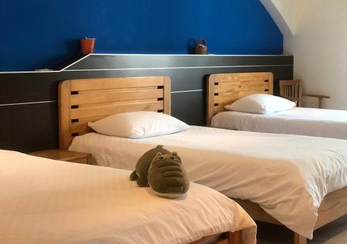 un animale di peluche seduto su un letto in una stanza di Matsu B&B a Nangan
