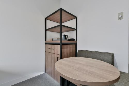 a wooden table and two chairs in a room at Vessel Inn Keisei Tsudanuma Station in Narashino