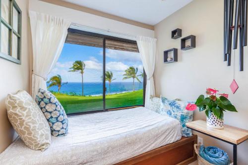 a bedroom with a bed and a large window at Oceanfront Condo with panoramic views! in Princeville