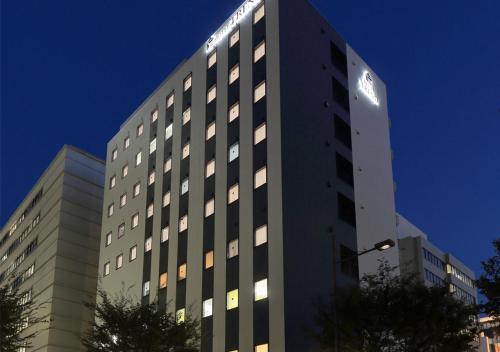 un edificio alto con luces encima en Hotel Trend Okayama Ekimae, en Okayama