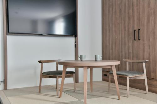 a table and two chairs and a table and a tv at Vessel Inn Keisei Tsudanuma Station in Narashino