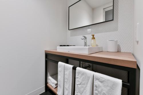 a bathroom with a sink and a counter with towels at Vessel Inn Keisei Tsudanuma Station in Narashino