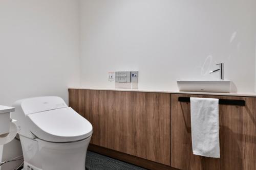 a bathroom with a toilet and a sink at Vessel Inn Keisei Tsudanuma Station in Narashino