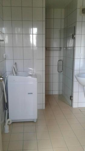a white tiled bathroom with a sink and a shower at GrandBeach Duplex Sea view by malai in Ban Tha Fat