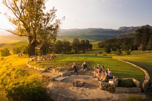 a group of people sitting around a fountain in a field at Berghouse and Cottages in Langkloof
