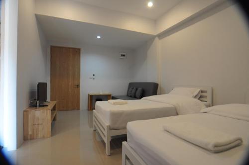 a hotel room with two beds and a television at NK place Phetchaburi in Ban Nong Som