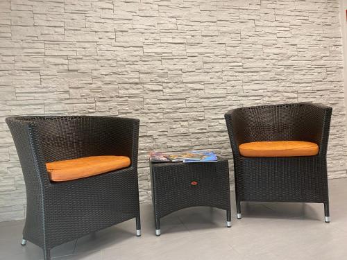 two chairs with orange cushions sitting next to a wall at Hotel Fürstenhof in Braunschweig