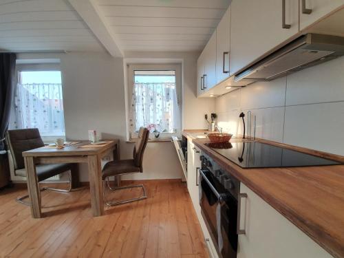 a kitchen with a wooden table and a wooden counter top at FeWo-Butze 3 Deichblick Strandnähe ca. 750m in Dornumersiel