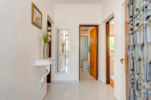 a hallway with white walls and a door with a vase at Newly refreshed property JOVI-relaxing, fenced, private, heated pool & view in Tugare